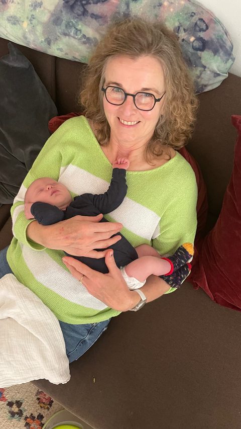 Edda Möller hält ein neugeborenes Baby liebevoll im Arm